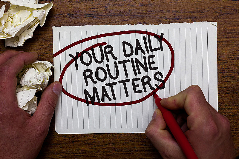文字标志显示你的日常事项。拥有健康生活的好习惯手持纸笔和红笔红圈黑字在白纸上。