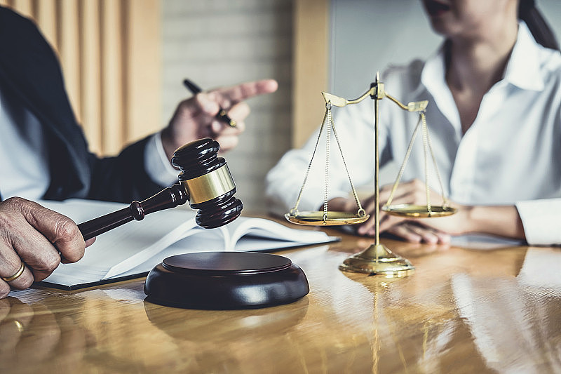 男律师或法律顾问在法庭会见客户，咨询房地产合同文件，法律及法律服务理念