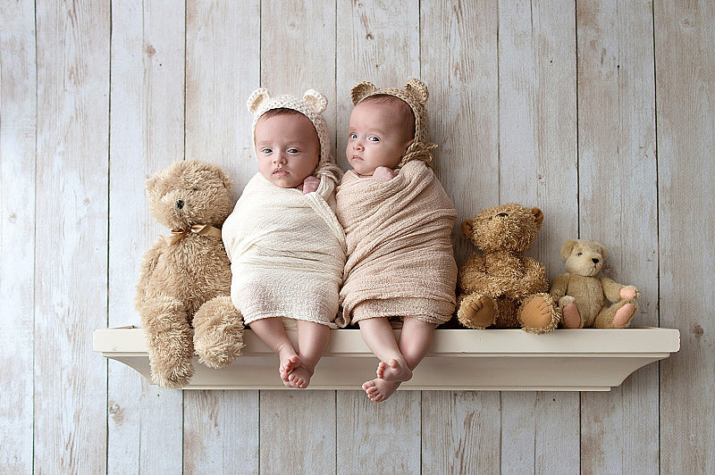 刚出生的双胞胎女孩戴着熊帽
