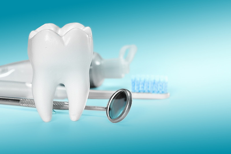 白色大健康牙齿和不同的牙科保健工具，在梯度牙科背景。