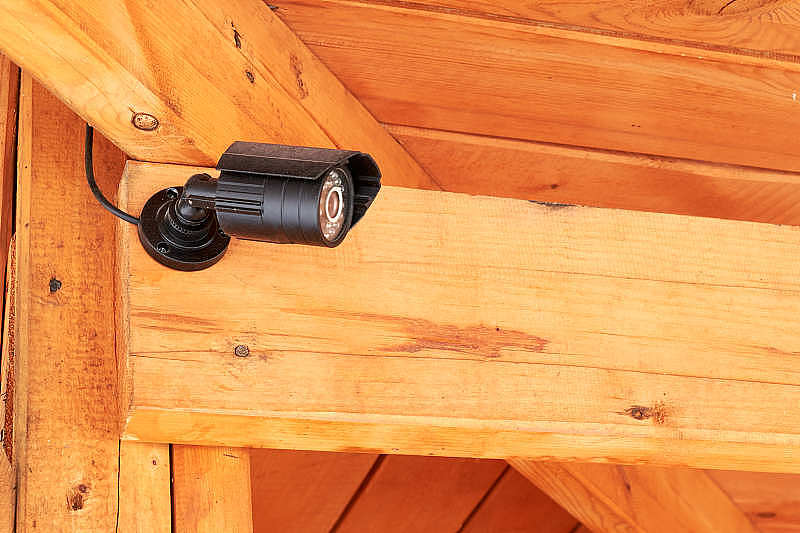 黑色安全监控摄像头。安装在木屋上的闭路电视摄像头。安全的概念。监控录像。