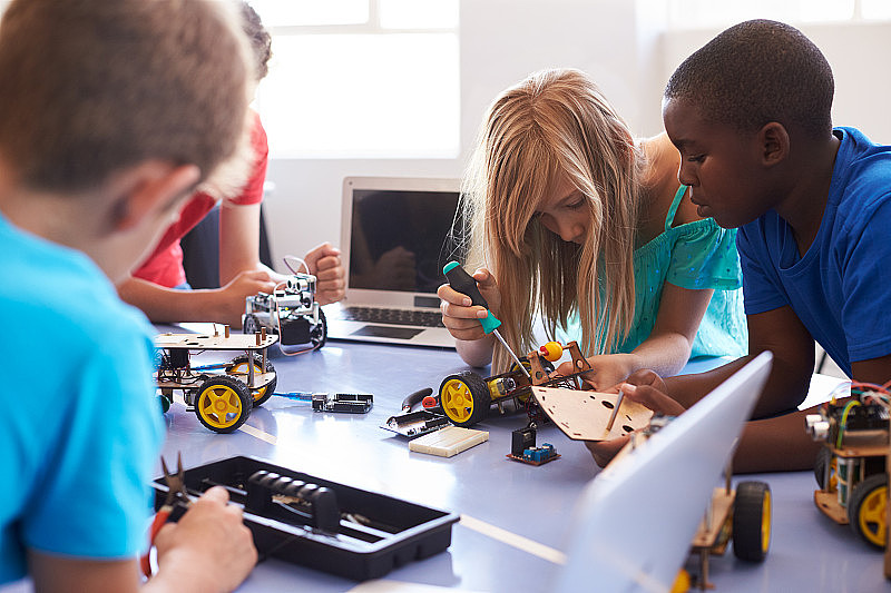 学生在课后计算机编码课上构建和学习编程机器人车辆