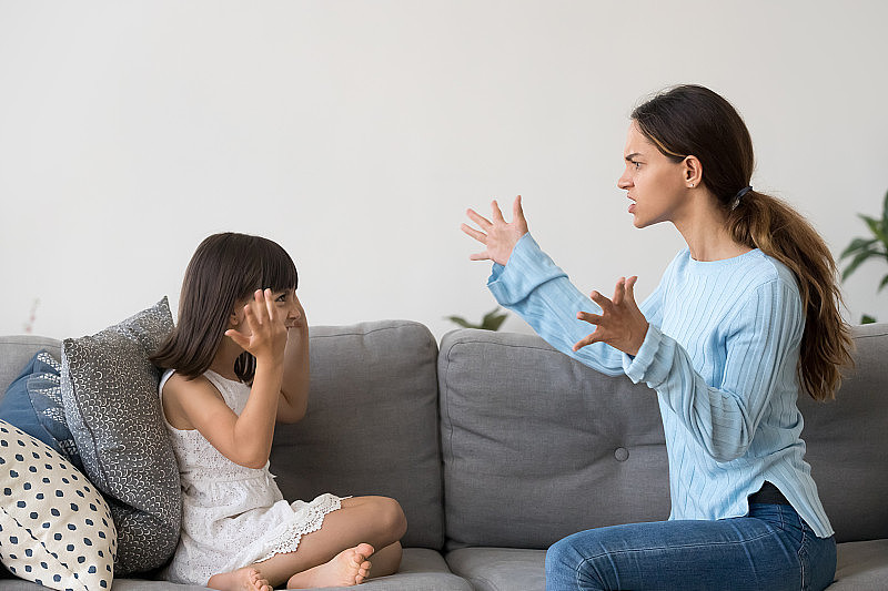 愤怒的年轻妈妈用手势和小孩争论