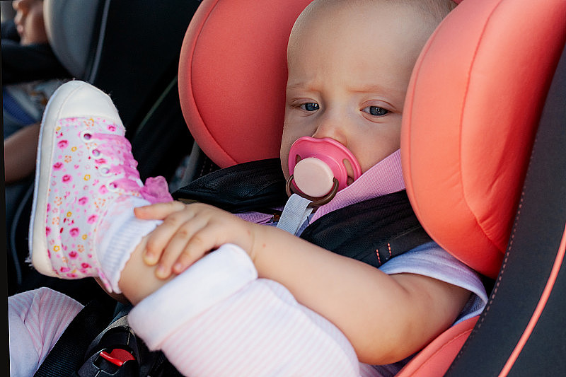 双胞胎男孩和女孩在汽车的儿童座位上。婴儿安全运输。一岁以下的孩子。