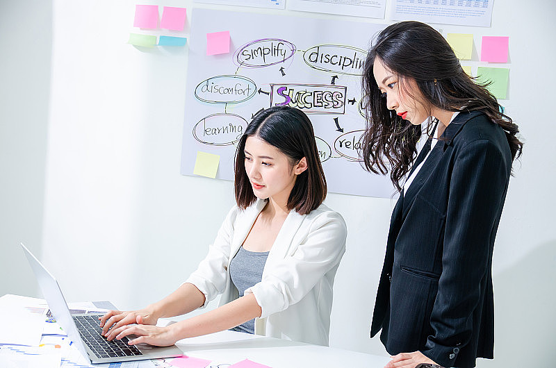 两位勤奋的亚洲年轻女企业家在一台笔记本电脑上一起工作，认真专注地阅读着屏幕，敏捷敏捷的理念