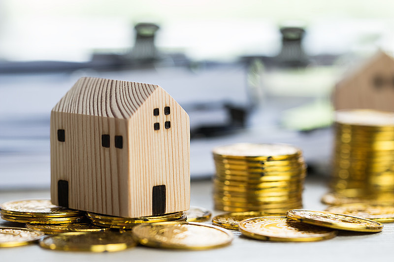 房屋抵押房产概念:房屋微型模型用叠钱硬币展示出售。提供投资按揭贷款的思路，管理协议大楼购买新住宅