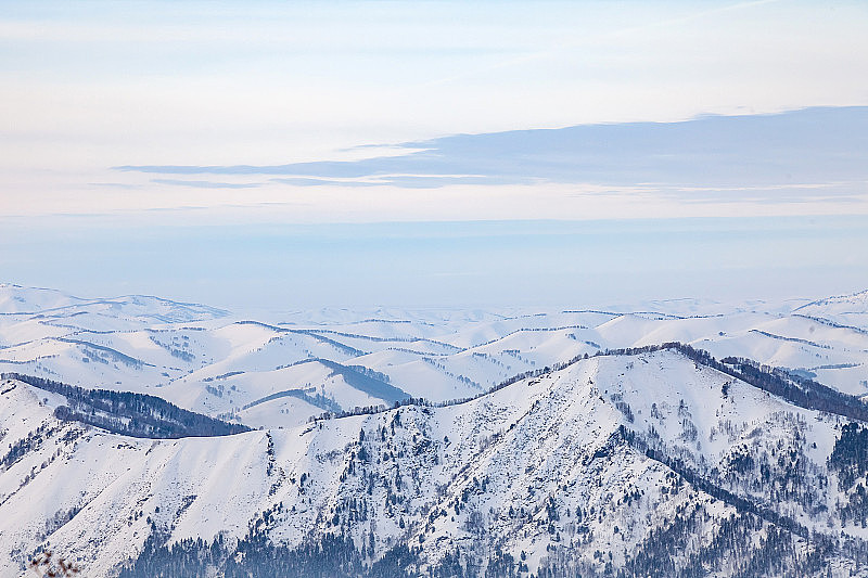 冬天，阿尔泰山的雪峰下，蓝天白云，风景如画。白色的雪和平静。