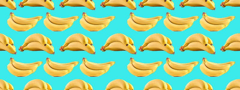 无缝照片模式与香蕉在蓝色的背景。创意背景横幅，网站，广告，名片和水果的特别优惠。背景与维生素