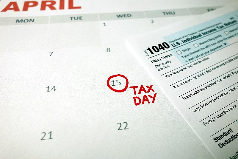 办公室办公桌上的日历显示纳税日期- 2020年4月15日与1040表格