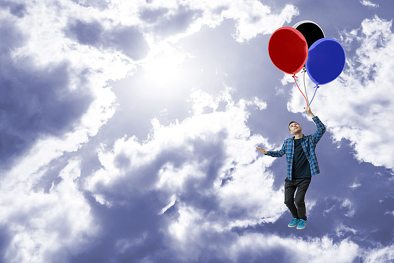 无忧无虑的概念和生活享受，梦想成真，人与气球在空中飞的高