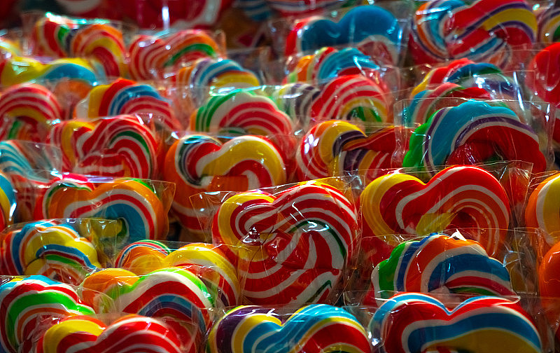 糖果店的彩色漩涡棒棒糖。为孩子们的派对准备的糖果。糖果天概念。螺旋彩虹色棒棒糖。不健康的食物。给孩子们的复古糖果。手工制作的漩涡棒棒糖。垃圾食品。