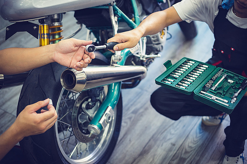 亚洲机械师在修车库里修复古摩托车。薄膜影响-选择性聚焦