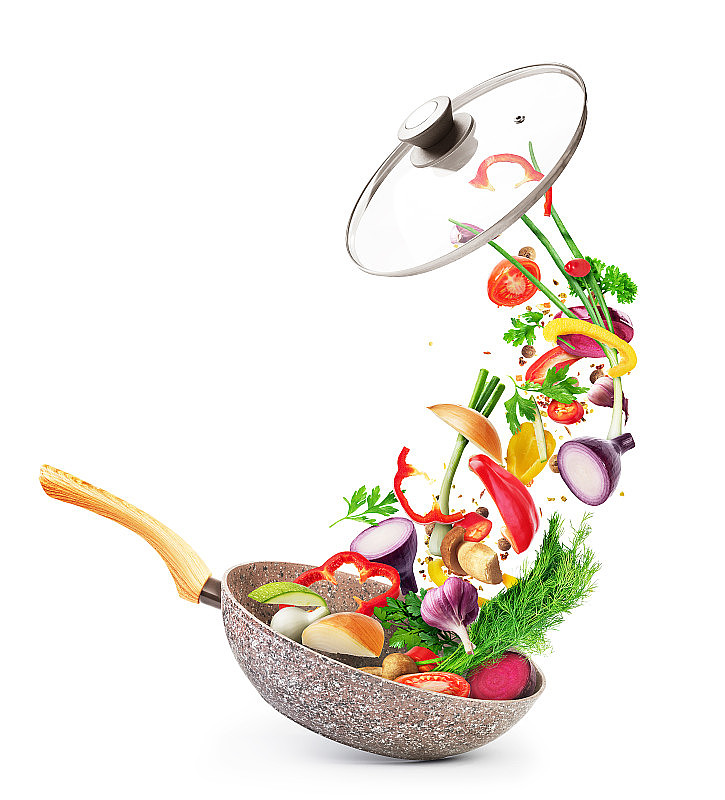 烹饪概念。蔬菜和培根落在一个孤立的平底锅上，背景是白色的。健康食品。