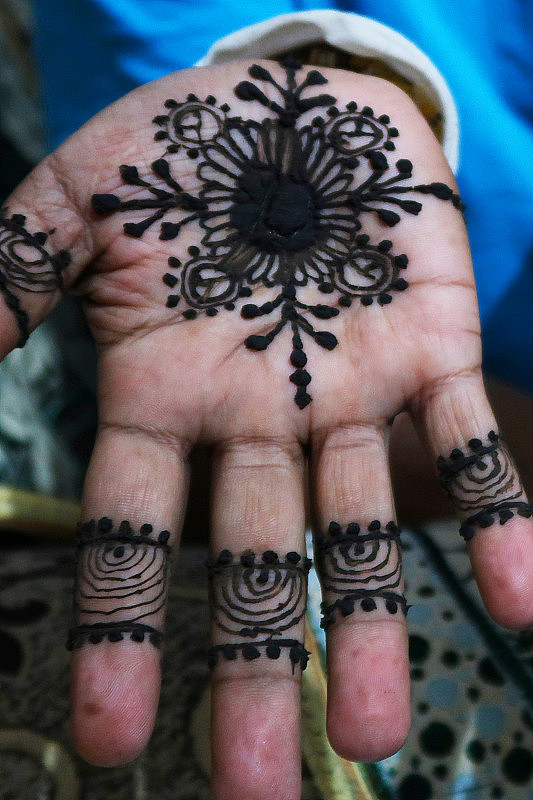 一个不认识的男人用指甲花或曼海蒂粘贴纹身设计展示自己的手，这是印度次大陆的婚礼传统，被称为曼海蒂仪式，为新娘和新郎带来积极的精神，健康，繁荣和好运。