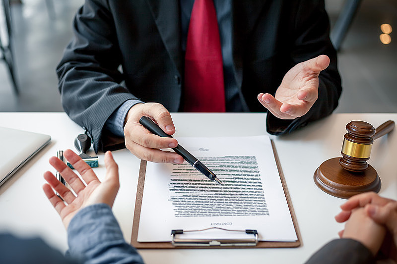 商人和律师在合同、协议文件上签字。