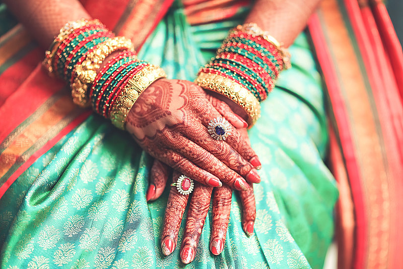 在一个典型的印度教婚礼上，印度新娘美丽的女性手与曼海蒂和珠宝