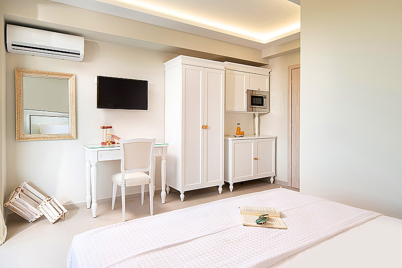 白色优雅的小工作室公寓房间与古典风格的设计木板家具在现代酒店公寓。