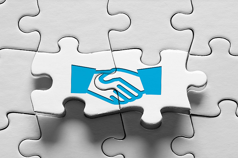 商业协议、共识、战略联盟或伙伴关系。有握手图标的拼图。