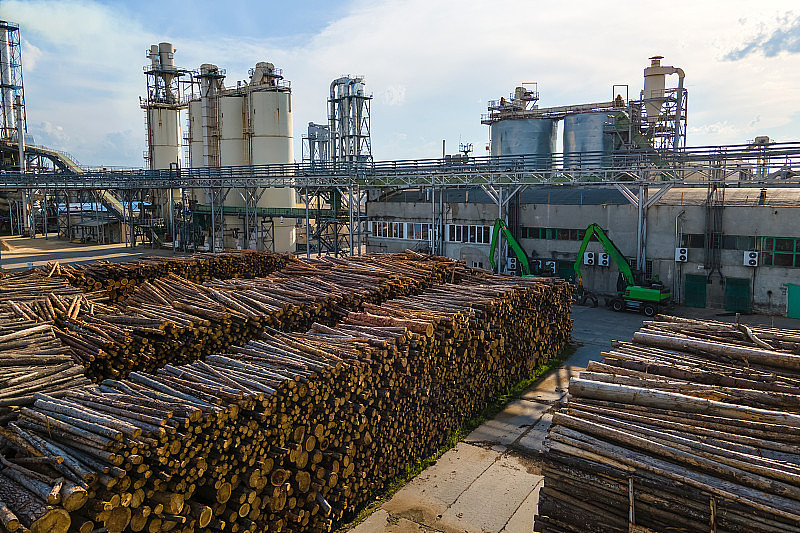 鸟瞰图木材加工厂与木材成堆的工厂制造庭院。