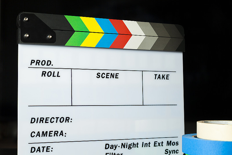 电影拍板与彩色标记磁带在互联网内容生产者黑暗背景工作室。