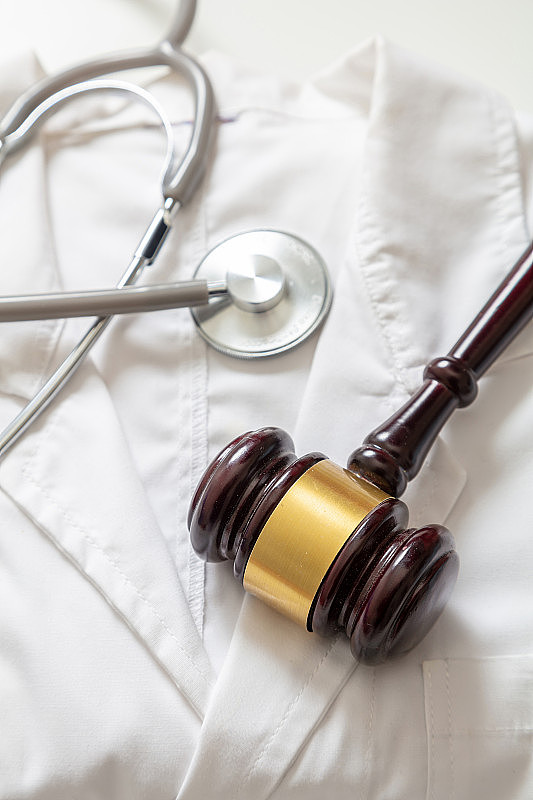 健康和法律。医疗事故，人身伤害律师法官用木槌，医生用听诊器