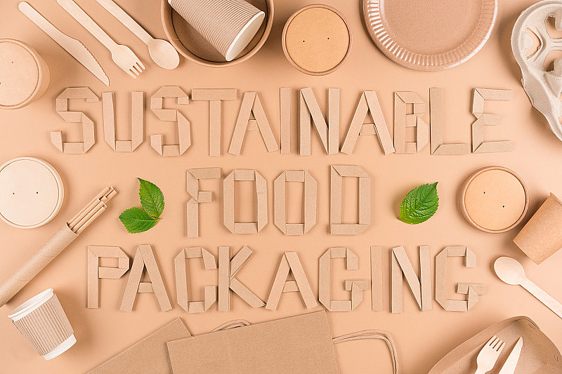 可持续食品包装概念-纸制餐具，木制餐具，纸杯，盘子，袋子和淡棕色背景的食品容器。平躺