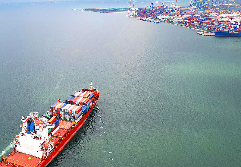 国际贸易概念。集装箱航运业务鸟瞰图进出口物流航运船舶驶向港口，由大型货船运输。
