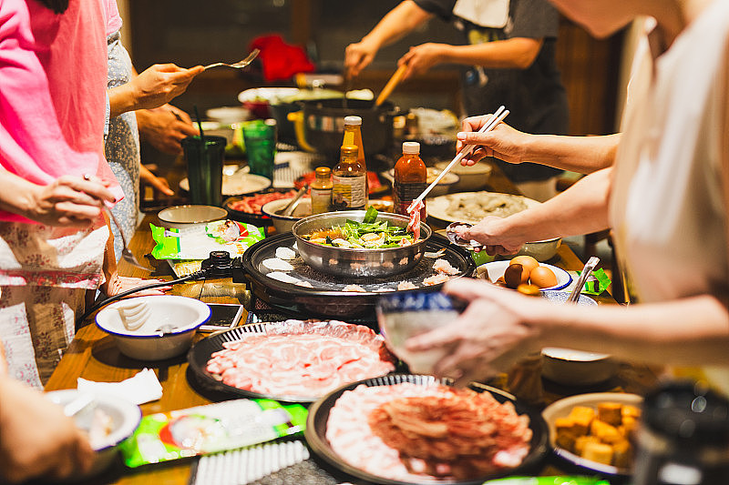 一群朋友在家里煮中国涮火锅。