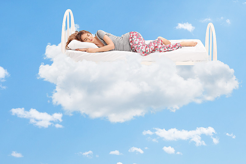 在云里的一张舒适的床上睡觉的女人