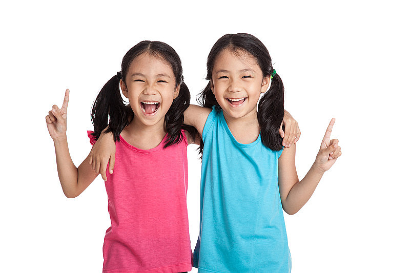 快乐的亚洲双胞胎女孩微笑点起来
