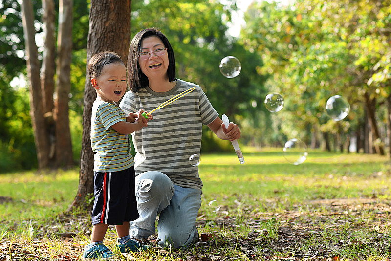 亚洲小孩和妈妈玩泡泡棒