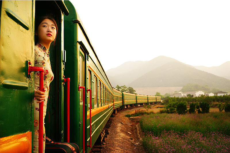 年轻女子背着行李坐着老式火车，