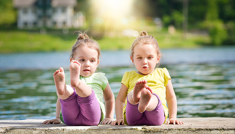 双胞胎女孩在湖岸锻炼