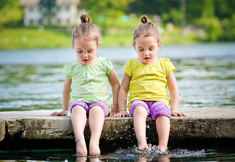 双胞胎女孩在湖岸锻炼