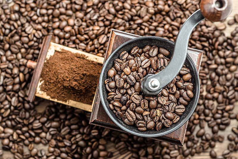 手动咖啡研磨机的背景模糊的咖啡豆。
