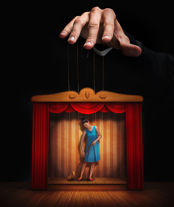 男人的手控制着一个小女人的木偶