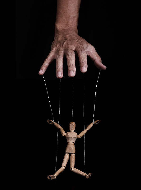 手控制木制木偶，低关键的形象，在黑色的背景