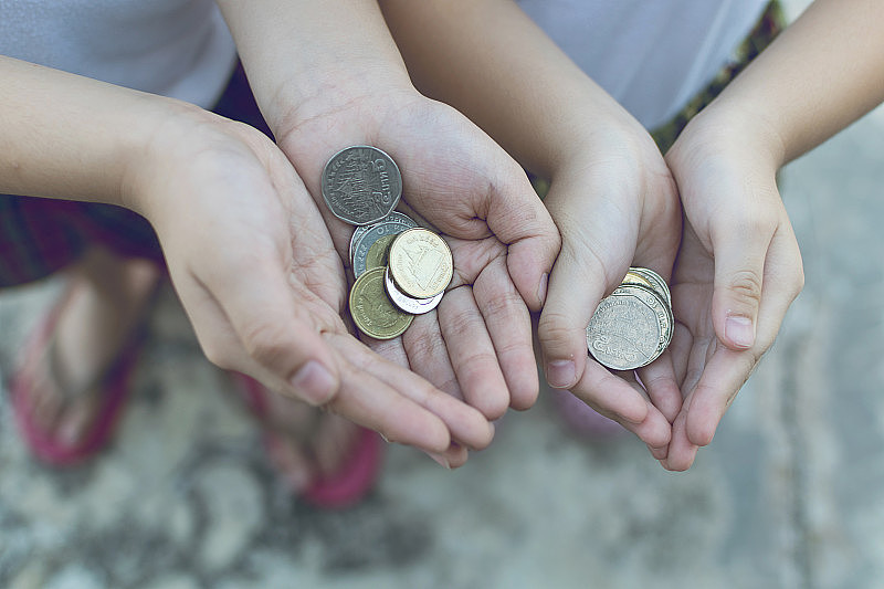硬币在孩子手中。商业和金融概念