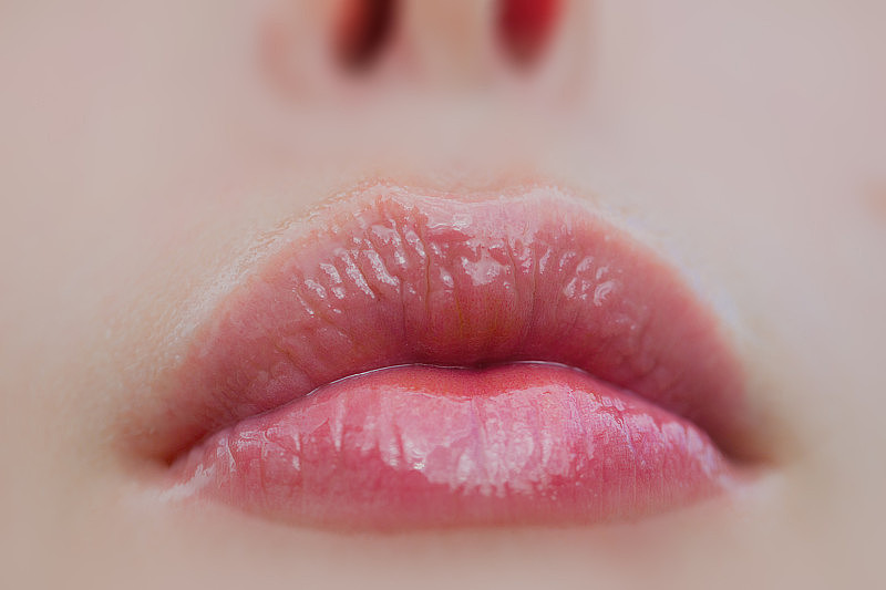 健康女性嘴唇没有疱疹。性感的嘴唇的女孩与唇膏。女人脸的一部分。嘴巴和鼻子美丽的年轻女士。有光泽的天然唇膏。化妆品和美容，化妆