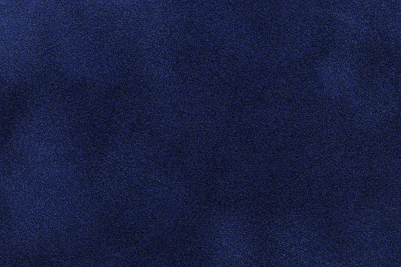 背景深蓝色麂皮织物特写。海军蓝磨砂织物的天鹅绒哑光纹理