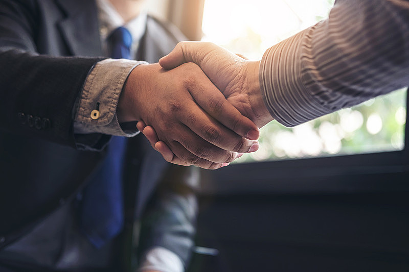 两个商人在会议期间握手，签署协议，成为一个商业伙伴，企业，公司，自信，成功的交易，他们的公司之间的合同