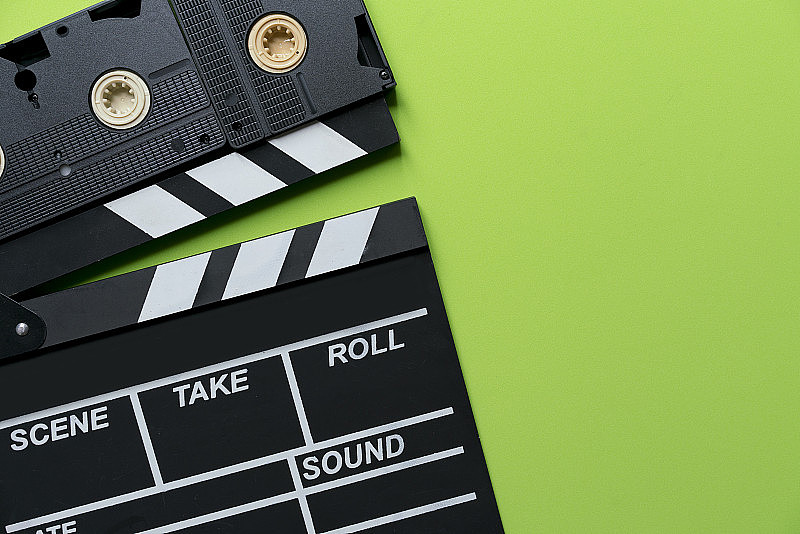 绿色背景的电影拍板和录像带;电影，电影和视频摄影概念