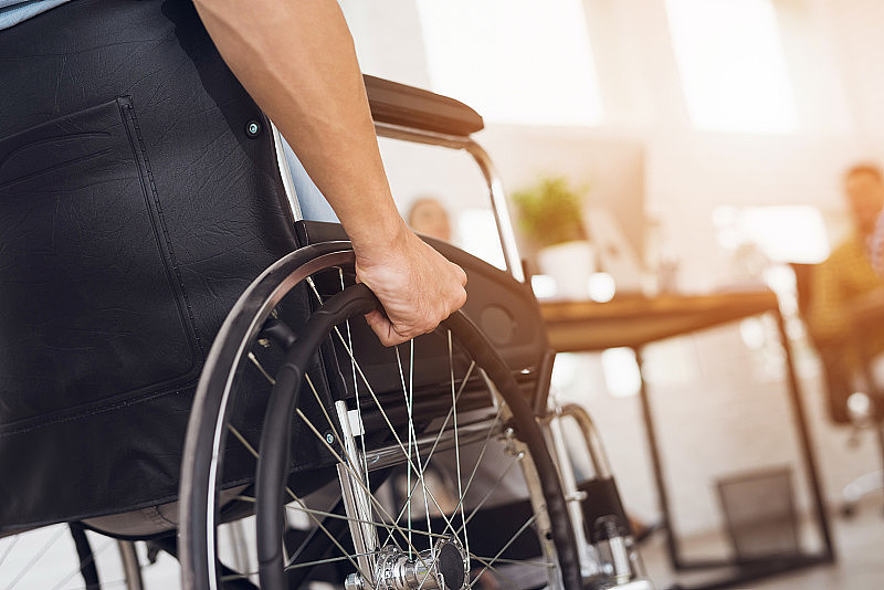 一个残疾人坐在轮椅上。