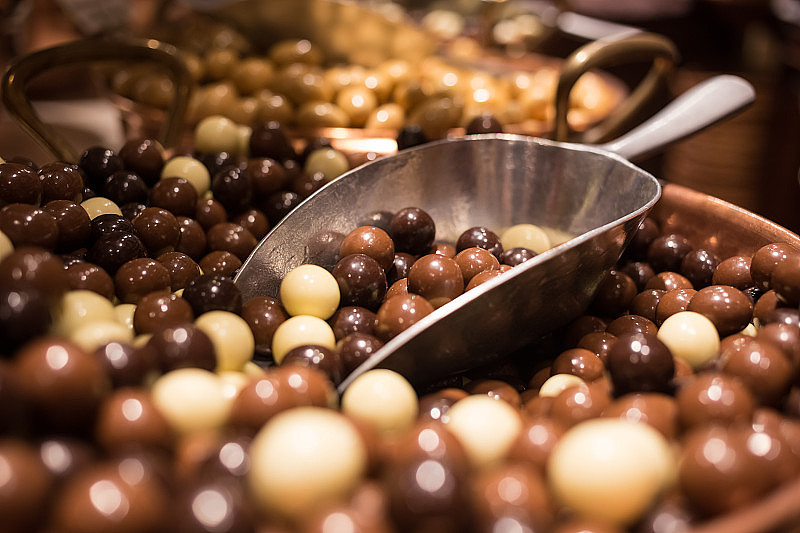 比利时美味的松露美味巧克力排成一行，糖果店一览无余。食品旅游旅游