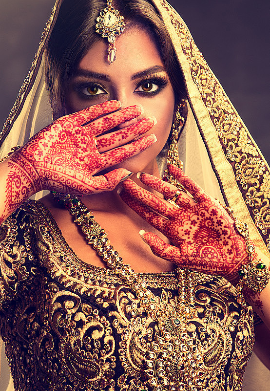美丽的印度女孩的肖像穿着传统民族服装和曼海蒂纹身在她的手上。