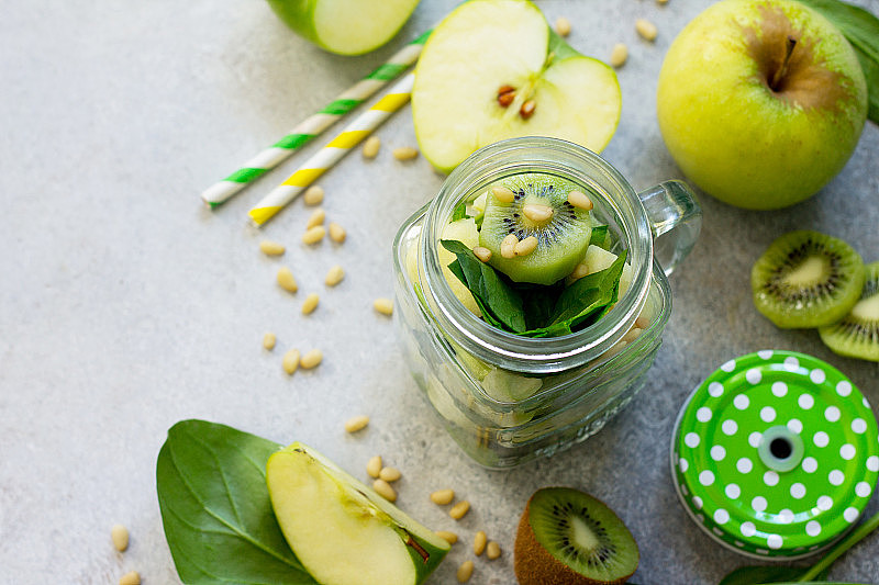 制作绿冰沙的原料:苹果，猕猴桃，菠菜，松子。健康素食的概念。副本的空间。