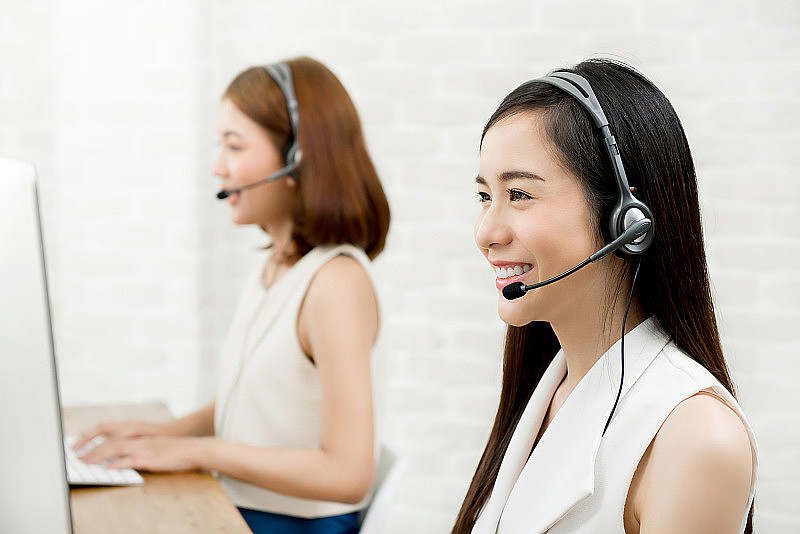 在呼叫中心工作的亚洲女性电话营销客户服务人员团队