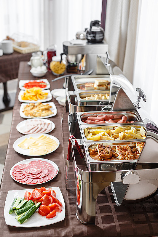 自助餐托盘加热准备服务。酒店的早餐是瑞典式自助餐。装不同食物的盘子