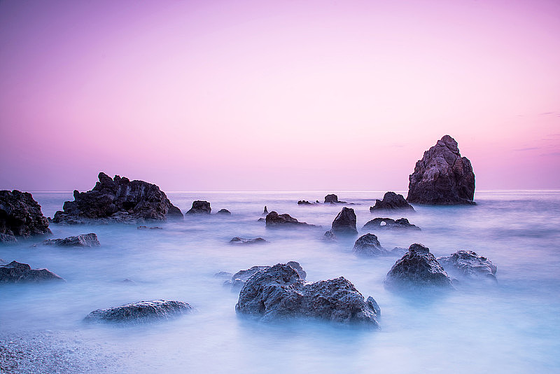 一个风景如画，神奇神秘的美丽风景与波浪和石头在海边的日落。(冥想、抗压、放松-概念)