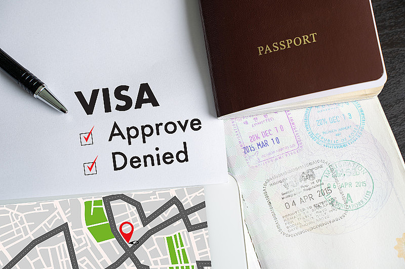 签证和护照到批准盖章的文件上俯视图在移民签证批准